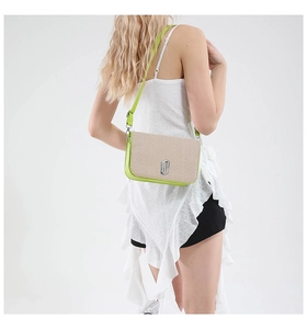Detail of neon green leather crossbody bag with beige woven straw flap and metal lock