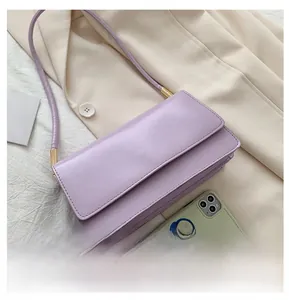 Detail of lavender rectangular shoulder bag with gold hardware and slim strap