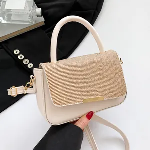 Close-up of beige textured handbag with elegant gold clasp and round handle