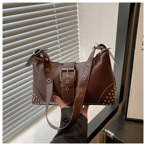 Detail of dark brown shoulder bag with silver studs and retro buckle accents