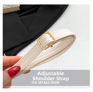 Close-up detail of the adjustable cream-colored shoulder strap with a gold buckle