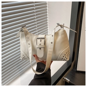 Detail of white Y2K leather tote bag featuring punk metal rivets and large silver buckles