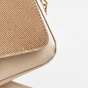 Detailed macro view showing premium woven straw and leather texture on a chic crossbody bag