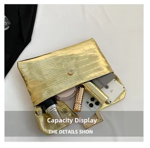 Macro view showing the internal capacity of the golden croc-effect envelope clutch bag