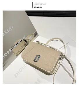 Detail of off-white square bag featuring woven texture and silver J-shaped metal buckle