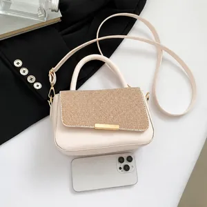 Cream textured handbag with top handle and strap shown next to a smartphone for size