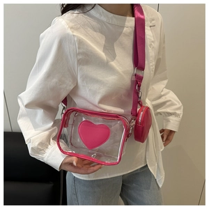 Scatto dettagliato di una borsa a tracolla trasparente con cuore rosa indossata da modella