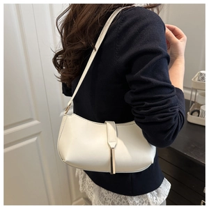 Side view of an elegant vintage white underarm shoulder bag with metal buckle detail