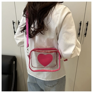 Trendy transparent crossbody bag with pink heart design worn by model