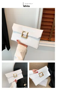 Close-up of white crocodile pattern envelope clutch with elegant gold square buckle