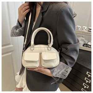 Detail of white PU leather bowling bag with twin flap pockets and smooth metallic zippers
