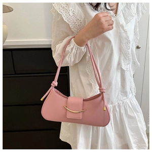 Primo piano di una borsa baguette rosa in stile francese con fibbia dorata lucida.