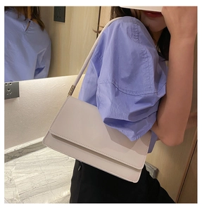 Close-up of minimalist cream-colored baguette bag showing matte faux leather texture