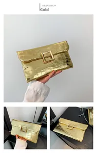 Detailed macro view of gold envelope clutch with faux crocodile texture and metal buckle