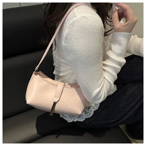 Elegant pink minimalist underarm shoulder bag with metal accent worn by a model