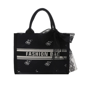 Black floral tote bag with white roses, fashion text, and black lace bow decoration