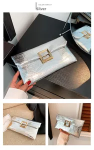 Detail of silver crocodile pattern envelope bag with a textured finish and golden buckle