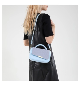 Elegante borsa a tracolla patchwork blu e lilla indossata da una modella di moda