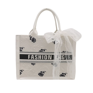 Creamy white tote bag with black rose print, ribbon detail and lace bow accessory