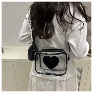 Vista posteriore di un outfit con borsa a tracolla trasparente decorata con un cuore nero