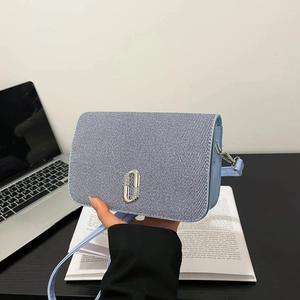 Light blue contrast crossbody square bag with silver ring buckle in a lifestyle setting