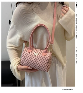 Detailed side view of pink boston bag with geometric pattern and butterfly buckle