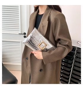 Silver crocodile texture envelope clutch bag with gold buckle styled on a model