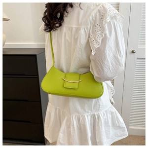 Dettaglio di una borsa sottobraccio francese verde lime indossata da una modella.