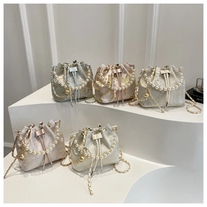 Collection of embroidered satin bucket bags with pearl handles and gold chain straps