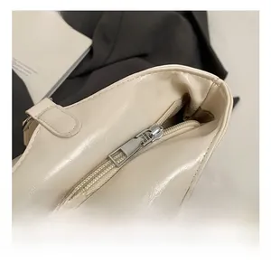 Macro shot of silver metal zipper and cream leather texture on minimalist tote bag