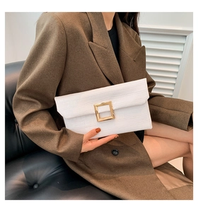Close-up of a white crocodile texture envelope clutch with a gold square buckle
