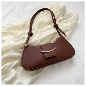 Primo piano di una borsa sottobraccio marrone in stile francese con fibbia in metallo