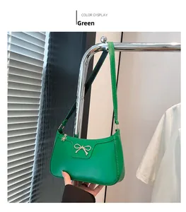 Détail du sac hobo vert avec nœud doré et pendentif de fermeture floral