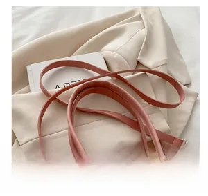 Detail of pink monogram handbag featuring white butterfly hardware and gold metal accents