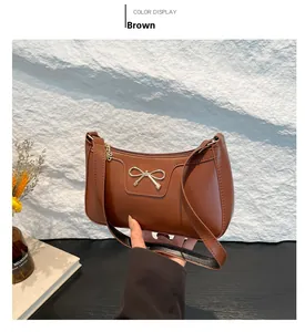 Vue détaillée du sac baguette en similicuir marron avec un nœud en métal doré