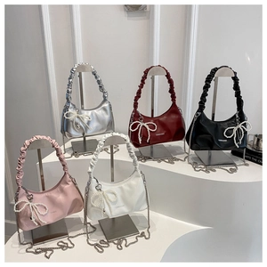 Detail of trendy pleated crescent underarm bags with pearl bow charms in five colors