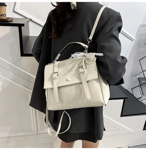 Vue arrière d'un sac messager vintage crème avec un accessoire de nœud en perles