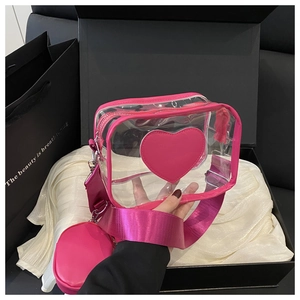 Detail of transparent PVC crossbody bag with hot pink heart patch and wide strap