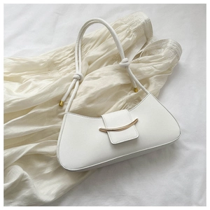 Dettaglio dell'elegante borsa sottobraccio bianca con decoro in metallo dorato