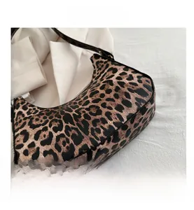 Vue détaillée du sac croissant à imprimé léopard avec bords noirs et texture élégante