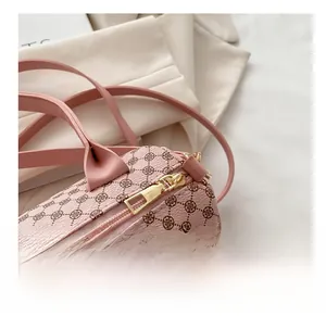 Detail showing smooth gold metal zipper and pink clover pattern on the barrel bag