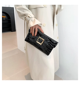 Detail of black crocodile pattern clutch bag with premium gold square buckle