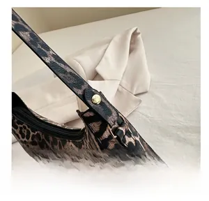 Vue détaillée du sac croissant imprimé léopard avec boucle dorée et fermeture éclair