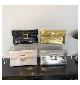 Detail view of crocodile pattern envelope clutch bags with gold metal clasps in four colors