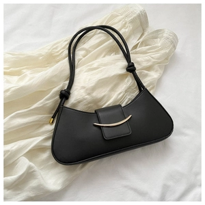Dettaglio di una borsa baguette nera chic con chiusura in metallo dorato a luna
