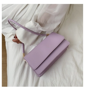 Detail of lavender purple faux leather shoulder bag with gold hardware and accordion folds
