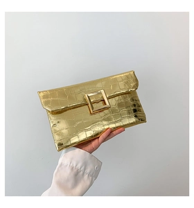 Detail of gold metallic crocodile pattern envelope clutch with a large square buckle