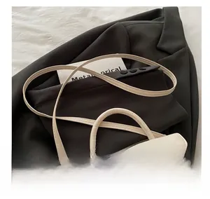 Detail of cream leather handbag with elegant metal twist lock and minimalist top handle