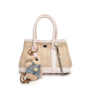 Straw shoulder bag with cream leather trim and cute plush bear charm for summer