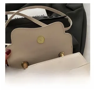 Detailed macro view of the premium metallic magnetic clasp and stitching on the beige bag